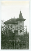 Photographie de la maison du jardinier de Riond-Bosson, Etienne Dolézal, derrière des arbres avec tuteurs