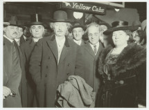 Photographie d'Ignace Paderewski entouré sans doute de membres de la communauté polono-américaine, lors d'une de ses tournées d'après-guerre, sous un panneau indiquant «Yellow Cabs»